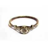 AN 18 CARAT GOLD RING ILLUSION SET WITH A SMALL ROUND CUT DIAMOND platinum setting and shoulders,