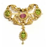 AN EDWARDIAN PINK TOURMALINE, PERIDOT AND SEED PEARL SET YELLOW GOLD DROP BROOCH the central oval