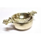 AN ASPREY & CO SILVER TEA STRAINER AND DISH the dish with scroll pierced decoration, scroll and