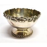 A WHITE METAL SMALL BOWL the round bowl on pedestal base with applied fruiting vine border,
