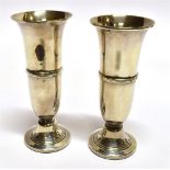 A PAIR OF SMALL SILVER TRUMPET VASES the fluted form vases on pedestal base (filled), hallmarked