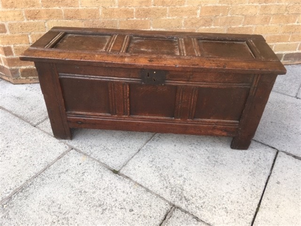 A PANELLED OAK COFFER on V cut end supports, 112cm wide 42cm deep 50cm high