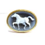 A BLUE AND WHITE HARDSTONE 9 CARAT GOLD OVAL BROOCH the carved hardstone depicting a prancing horse,
