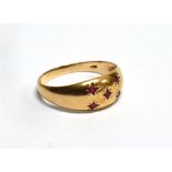 A 9 CARAT GOLD GRADUATING BAND RING gypsy set with five small rubies, ring size O, gross weight 2.