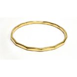 A 9 CARAT GOLD SLAVE BANGLE of round faceted form, hallmarked 9 carat gold, possibly weighted, gross