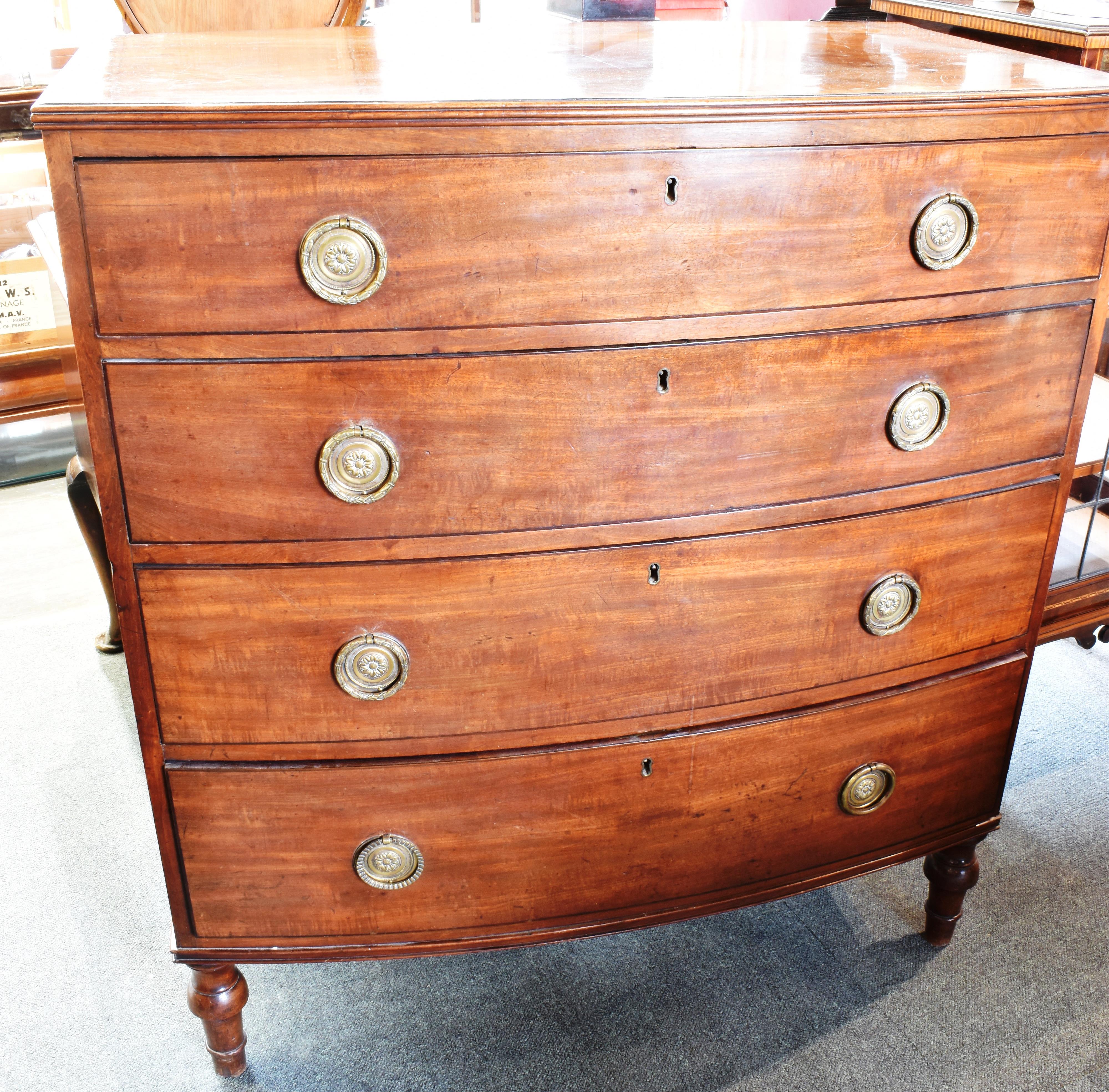 A GEORGE III MAHOGANY CHEST OF FOUR LONG GRADUATED DRAWERS with crossbanded decoration, on turned