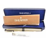 A SCHEAFFER FOUNTAIN PEN the black case with gold coloured wave design pattern, white dot to top
