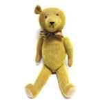 A GOLD MOHAIR TEDDY BEAR circa 1930s, probably English, with orange glass eyes and a black
