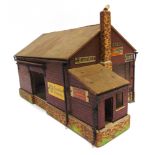 [O GAUGE]. A WOOD & HARDBOARD GOODS SHED the external walls with six printed tin signs, overall 33cm