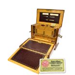 AN EDWARDIAN TRAVELLING STATIONERY BOX with gilt metal carrying handle to each side, with Bramah