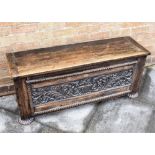 A CONTINENTAL OAK COFFER the front and sides with carved decoration, 113cm wide 34cm deep 47cm high