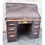 AN EDWARDIAN TWIN PEDESTAL OAK ROLL TOP DESK the serpentine tambour top opening to fitted