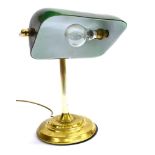 A CONTEMPORARY DESK LAMP with green glass shade and brass base, the shade 23cm wide