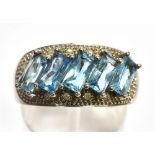 A BLUE TOPAZ FIVE STONE SET 9CT WHITE GOLD RING with small round brilliant cut pavé set diamonds,