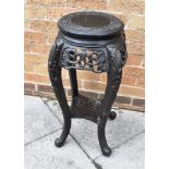 A CHINESE CARVED AND EBONISED HARDWOOD PLANTSTAND the circular top 29cm diameter, 70cm high