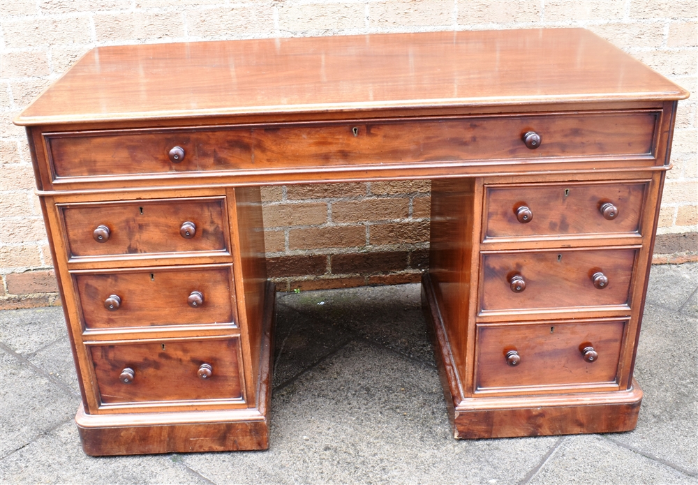 A MAHOGANY TWIN PEDESTAL DESK with plain top and single long frieze drawer above pedestals each