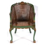 A BERGERE ARMCHAIR with double caned back, the carved frame with green lacquered Chinoiserie