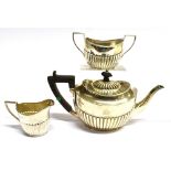 A SILVER THREE PIECE BACHELOR TEA SET the oval shape of half fluted design teapot with hardwood