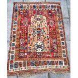 A HAND WOVEN PRAYER RUG decorated with stylised plants and animals, 185cm x 130cm