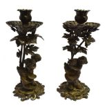 A PAIR OF PATINATED METAL ROCOCO STYLE FIGURAL CANDLESTICKS the bases modelled as Bacchanalian