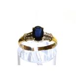 A 14CT GOLD SAPPHIRE SINGLE STONE RING WITH WHITE STONE SET SHOULDERS the oval cut blue sapphire