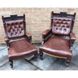 A PAIR OF VICTORIAN CARVED WALNUT FRAMED ARMCHAIRS with button upholstered backs, on brass casters