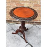 A HIGHLY CARVED VICTORIAN MAHOGANY OCCASIONAL TABLE the circular top 51cm diameter, 68cm high