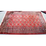 A LARGE RED GROUND RUG 236cm x 155cm