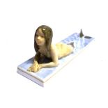 A ROYAL COPENHAGEN FIGURE OF A MERMAID lying in shallow water on a rectangular base, 19.5cm long,