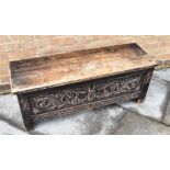 A CONTINENTAL OAK COFFER the front and sides with carved decoration, 112cm wide 37cm deep 43cm high