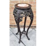 A CHINESE CARVED HARDWOOD PLANTSTAND with marble inset top, the circular top 27cm diameter, 92cm