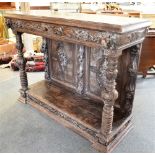 A CARVED OAK BUFFET with frieze drawer flanked by lion masks above carved pilasters and pot shelf