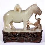 A CHINESE CARVED JADE FIGURE OF A HORSE standing tethered to a post, whilst a crouching monkey