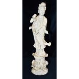 A BLANC DE CHINE FIGURE OF GUANYIN standing holding a lotus flower, 38cm high
