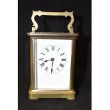 A BRASS FRAMED CARRIAGE CLOCK the enamel dial with Roman numerals, 12cm high