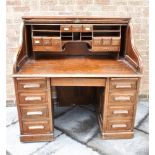 A TWIN PEDESTAL OAK ROLL TOP DESK the serpentine tambour top opening to fitted interior, 127cm
