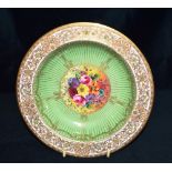 A ROYAL WORCESTER DISH the centre painted with a spray of flowers signed by William Hale, on a green