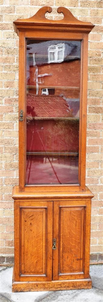 A VICTORIAN OAK SIDE CABINET OF NARROW PROPORTIONS with swan neck pediment and shaped cornice