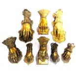 EIGHT BRASS LETTER CLIPS each in the form of a hand, the largest 19cm high.