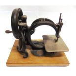 A WILLCOX & GIBBS SEWING MACHINE set to a wooden base, overall 32.5cm long.