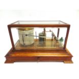 A BAROGRAPH IN AN OAK CASE with bevelled glazing and a drawer to base, 20cm high, 37.5cm wide,
