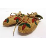 A PAIR OF NATIVE NORTH AMERICAN CHILD'S BEADWORK MOCCASINS with soft soles, each 14cm long.