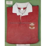 A framed Phil Bennett Llanelli RFC jersey,  the red jersey with white collar and stitched club