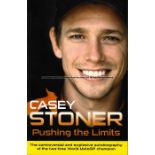 Casey Stoner signed MotoGP memorabilia, comprising signed book and 8 by 12in. action photograph of