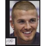 Trio of David Beckham framed presentations, the first a colour portrait photograph, 44 by 30cm.,