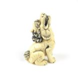 A Japanese carved ivory netsuke of a shishi, Meiji period (1868 - 1912).