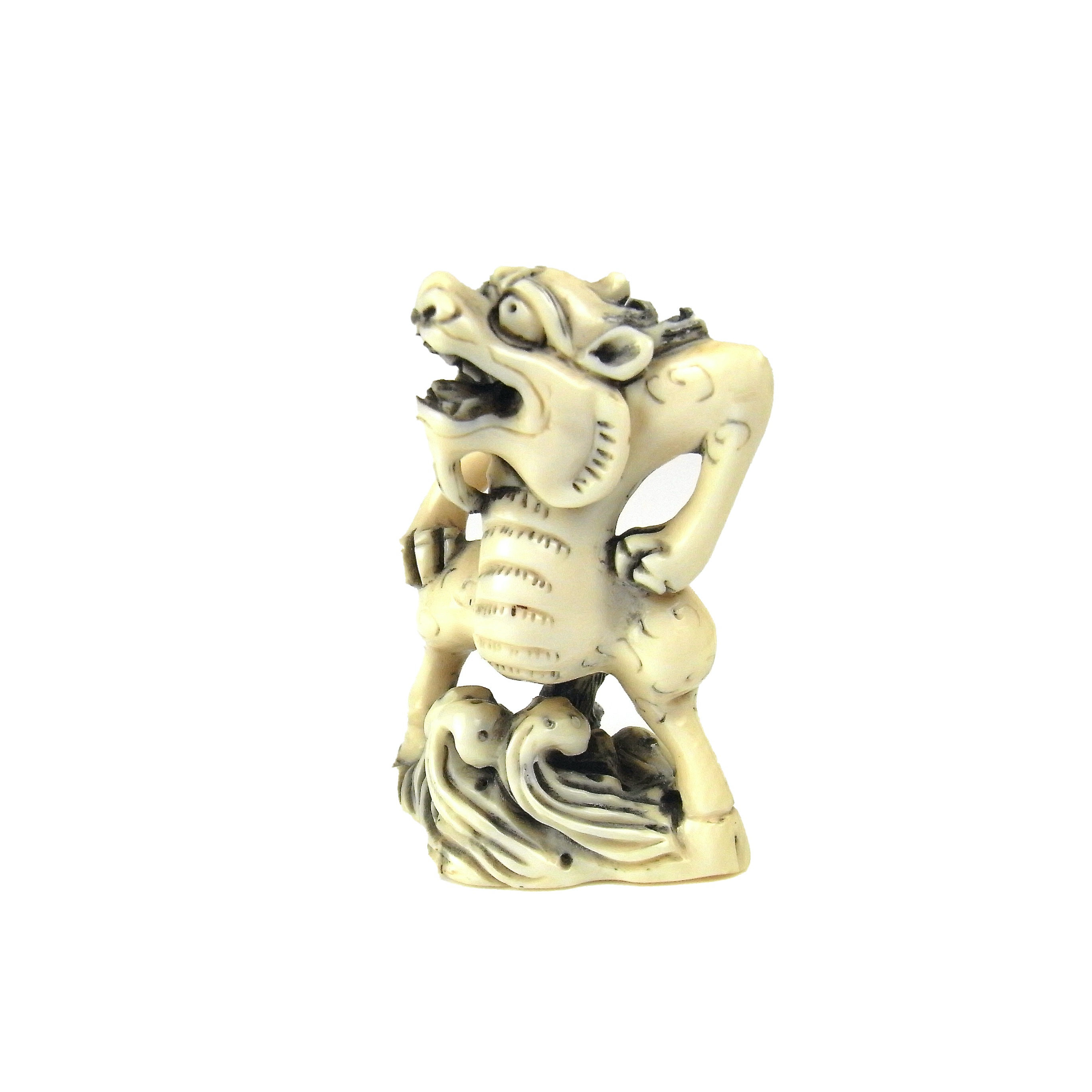 A Japanese carved ivory netsuke of a shishi, Meiji period (1868 - 1912).