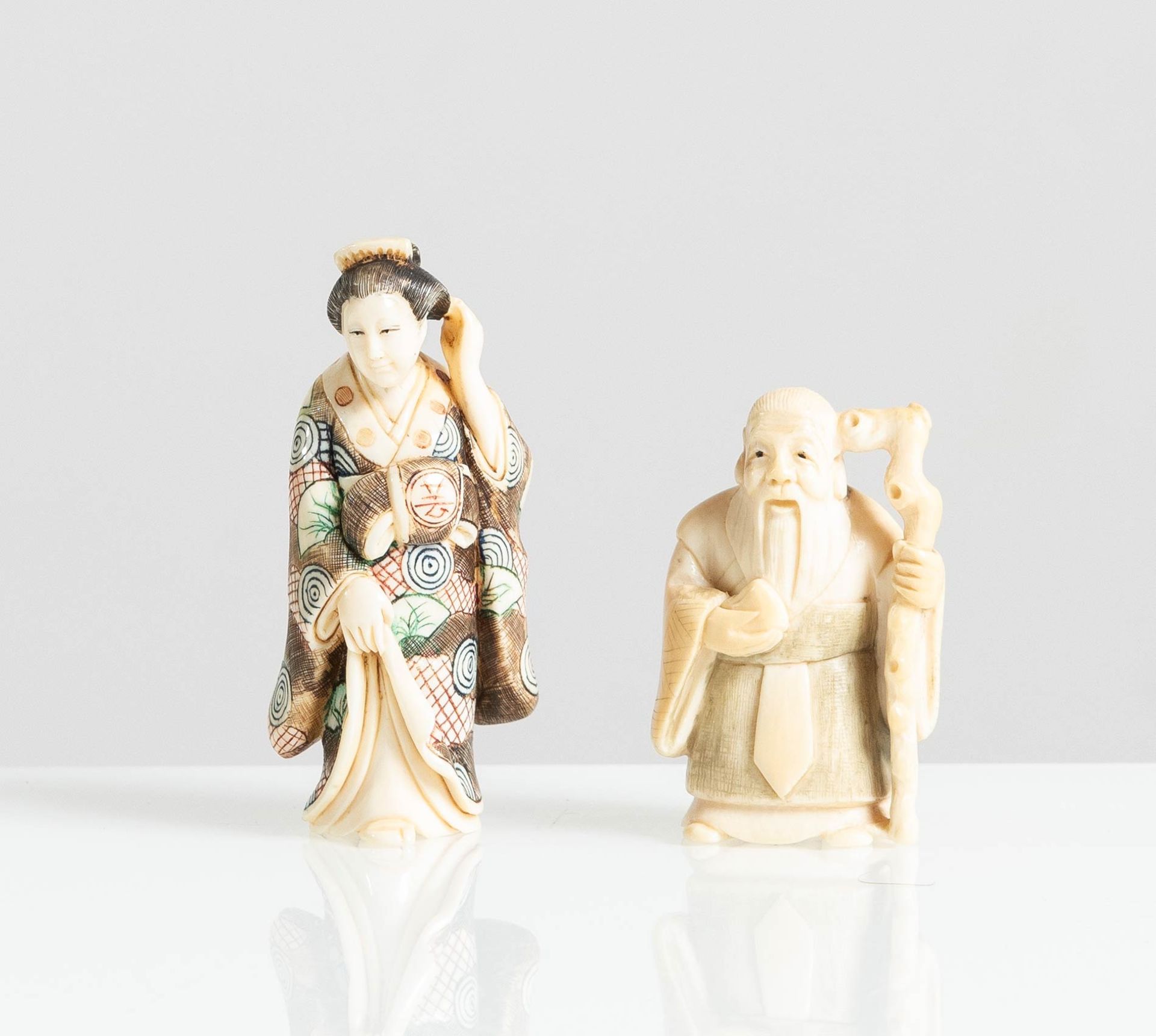 Coppia di Netsuke in avorio raffiguranti “Personaggi vari”, Giappone, XX sec.