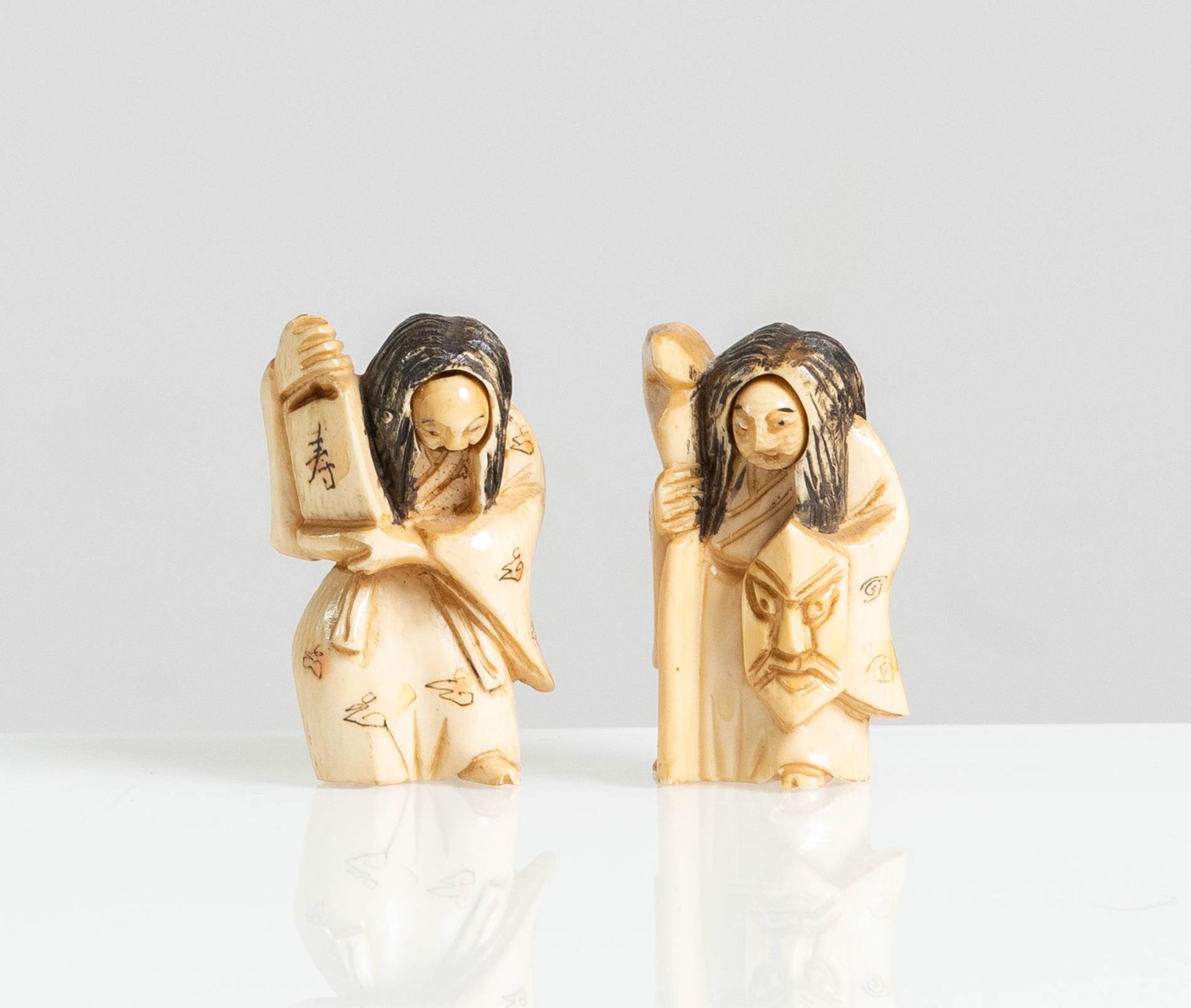 Coppia di Netsuke in avorio raffiguranti “Personaggi vari”, Giappone, XX sec.