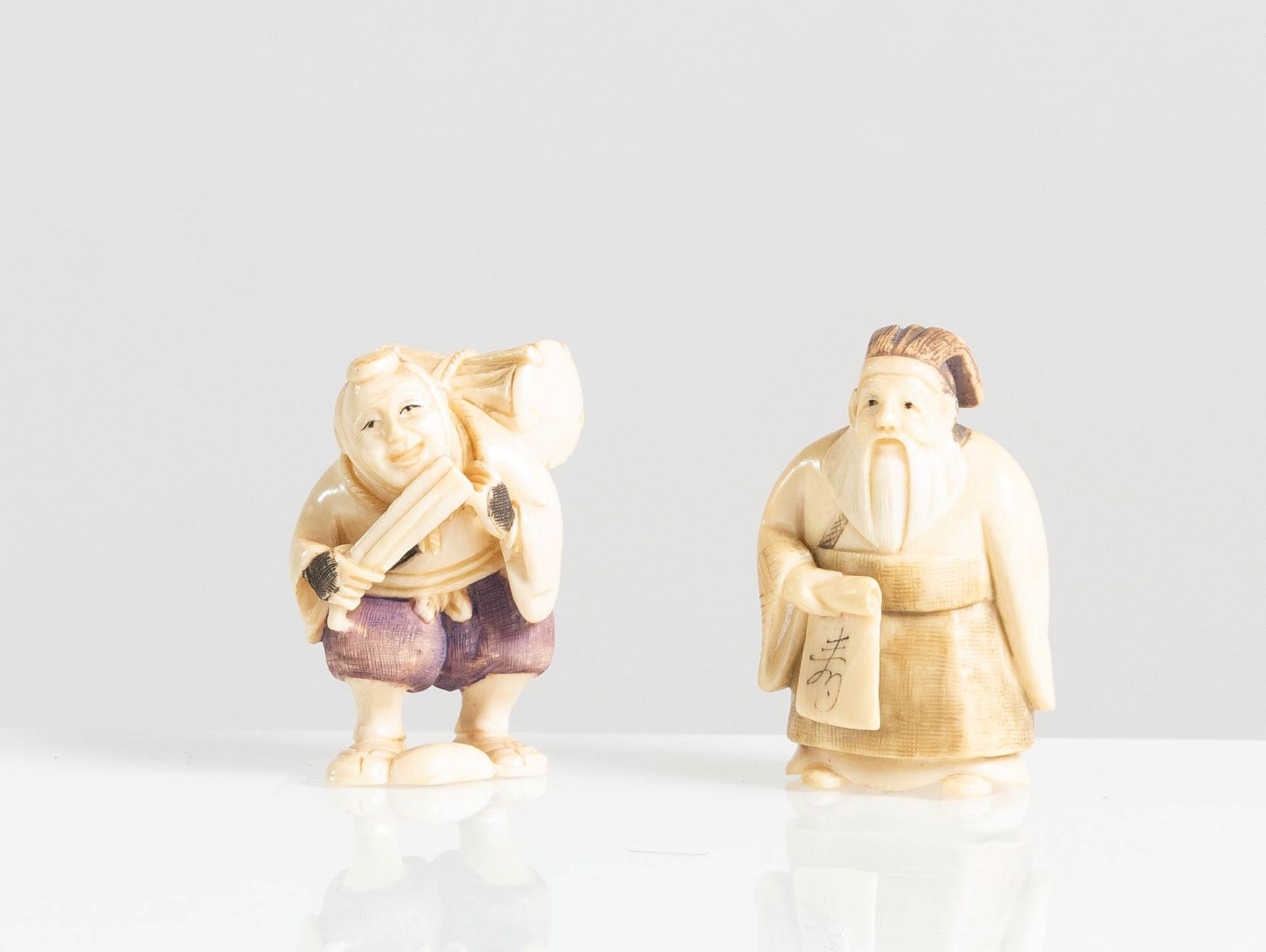 Coppia di Netsuke in avorio raffiguranti “Personaggi vari”, Giappone, XX sec.